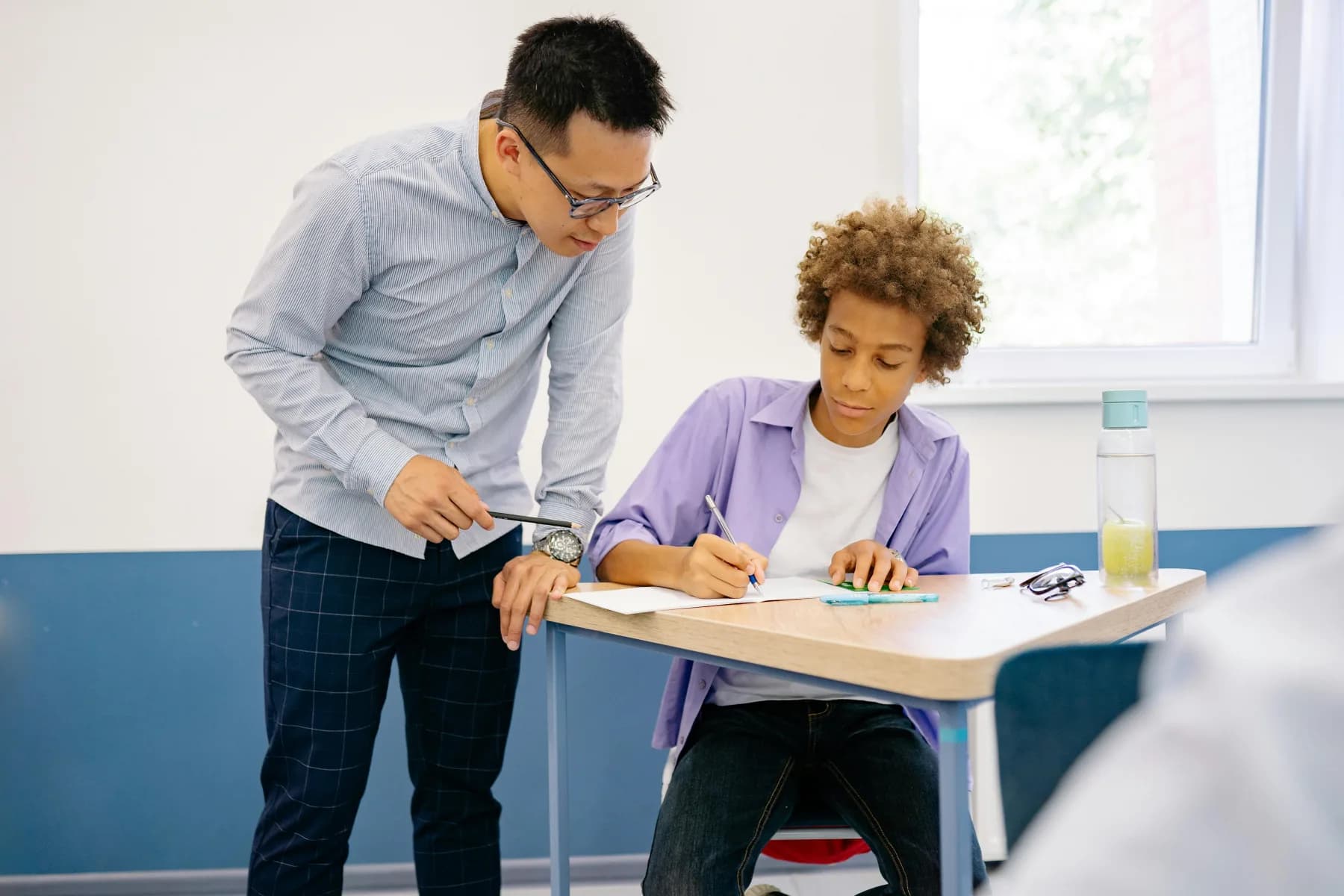 A mentor guiding a student through an assessment